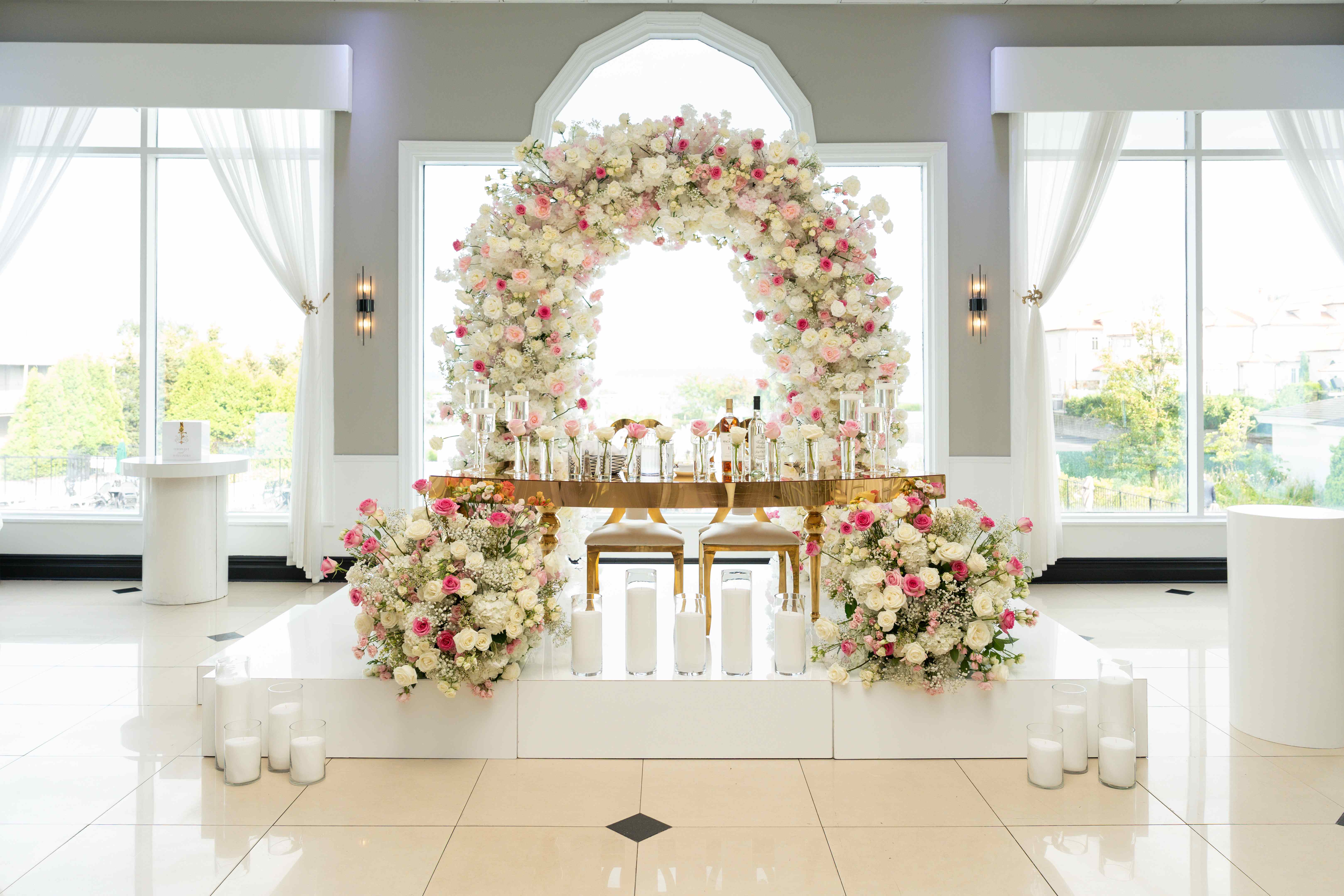 Complete wedding ceremony setup with floral arch and side arrangements